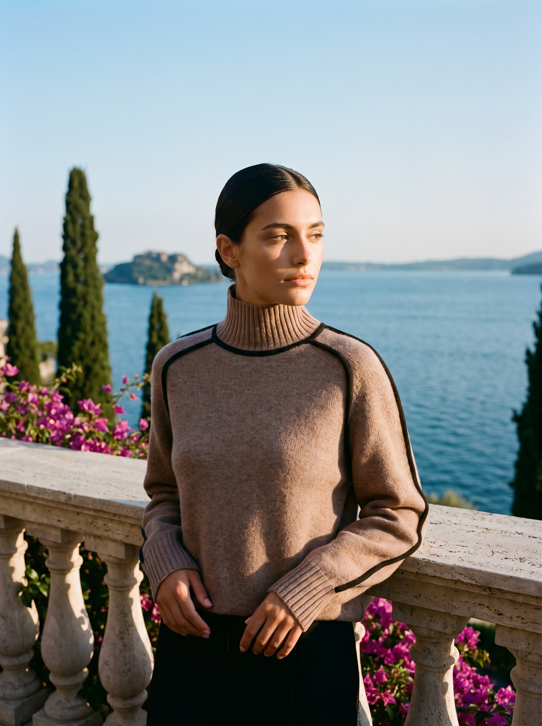 Woman wearing a brown contrast-trim turtleneck jumper on a terrace overlooking Lake Como, old money style — Aveloire
