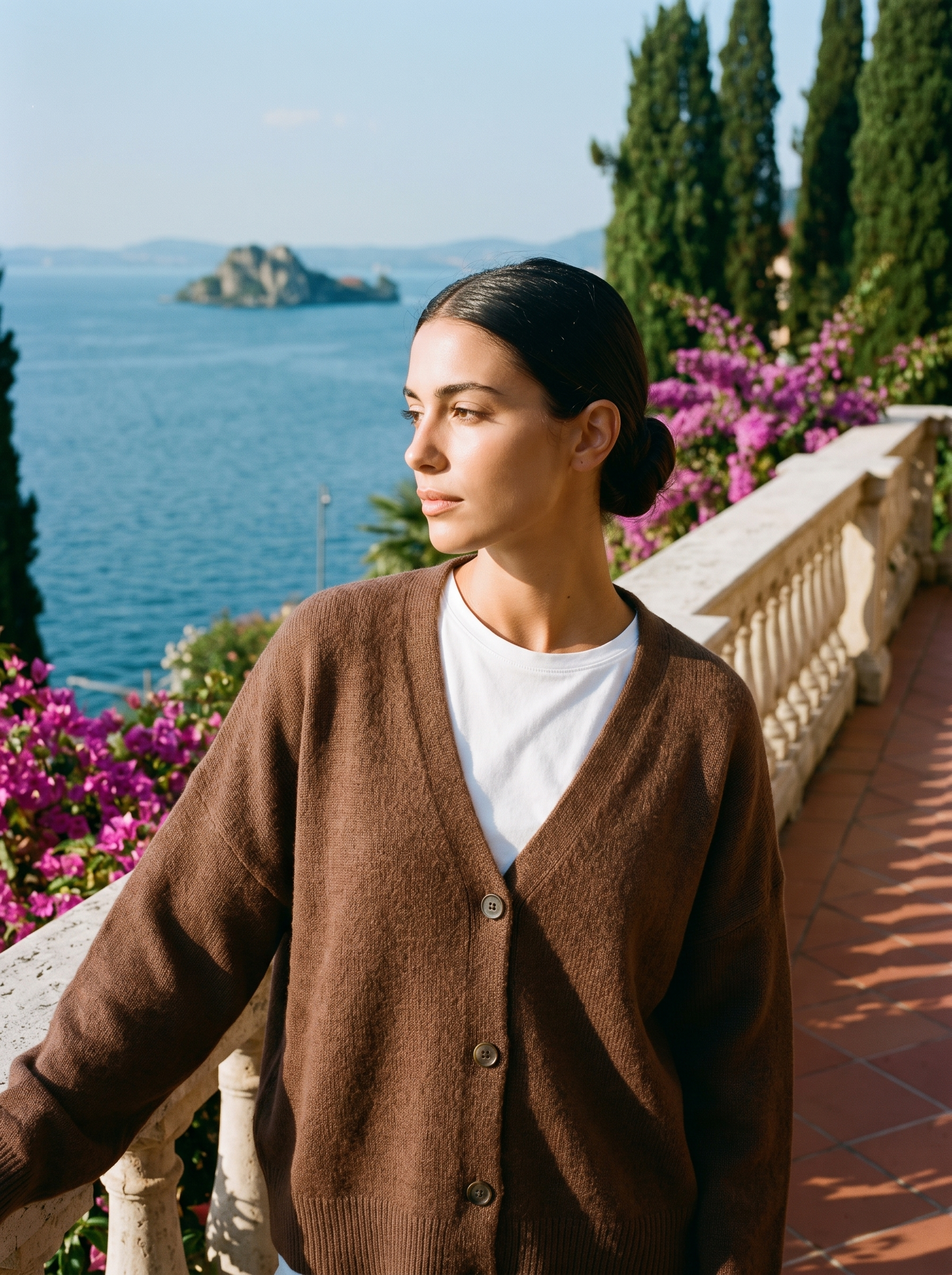 Woman wearing a brown V-neck cardigan on a terrace overlooking Lake Como, old money style — Aveloire