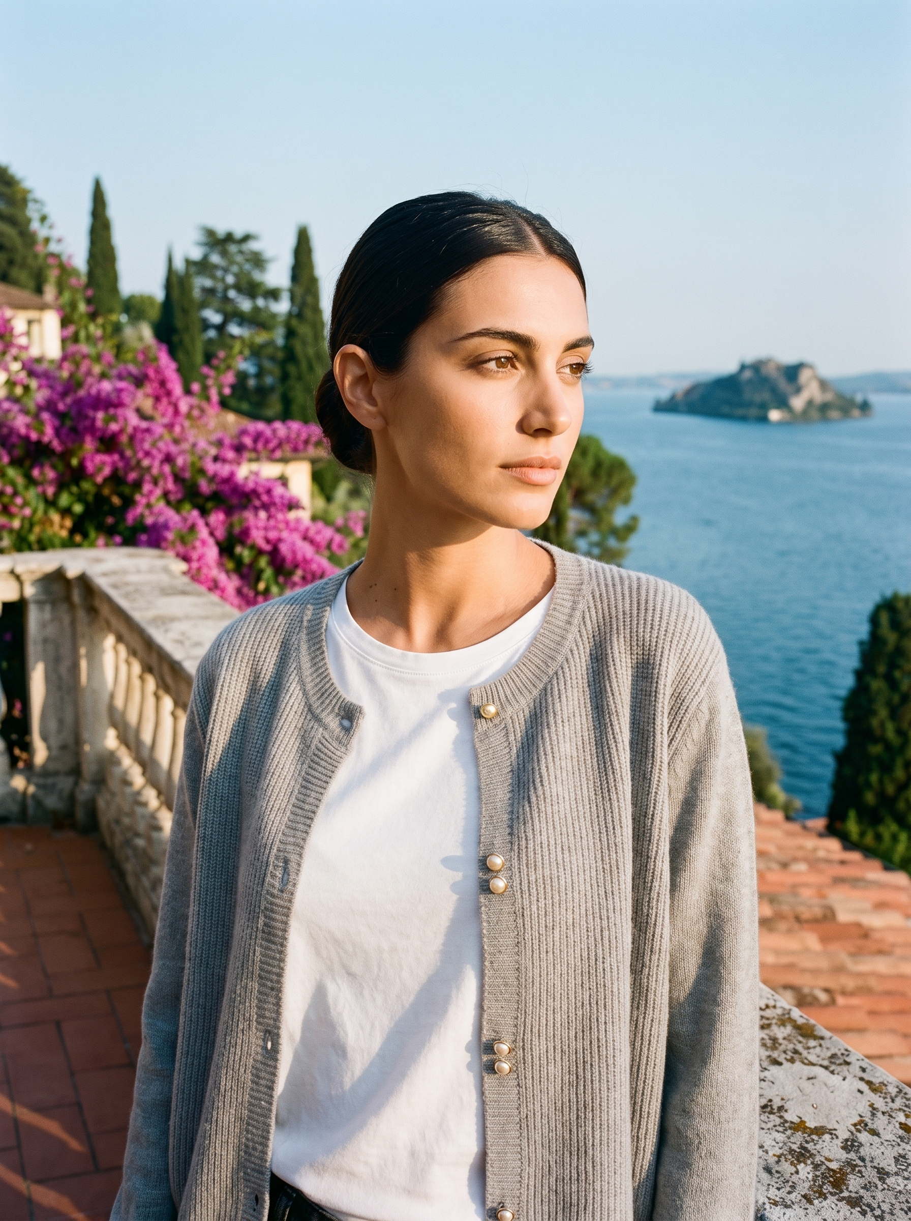 Woman wearing a gray round-neck cardigan on a terrace overlooking Lake Como, old money style — Aveloire