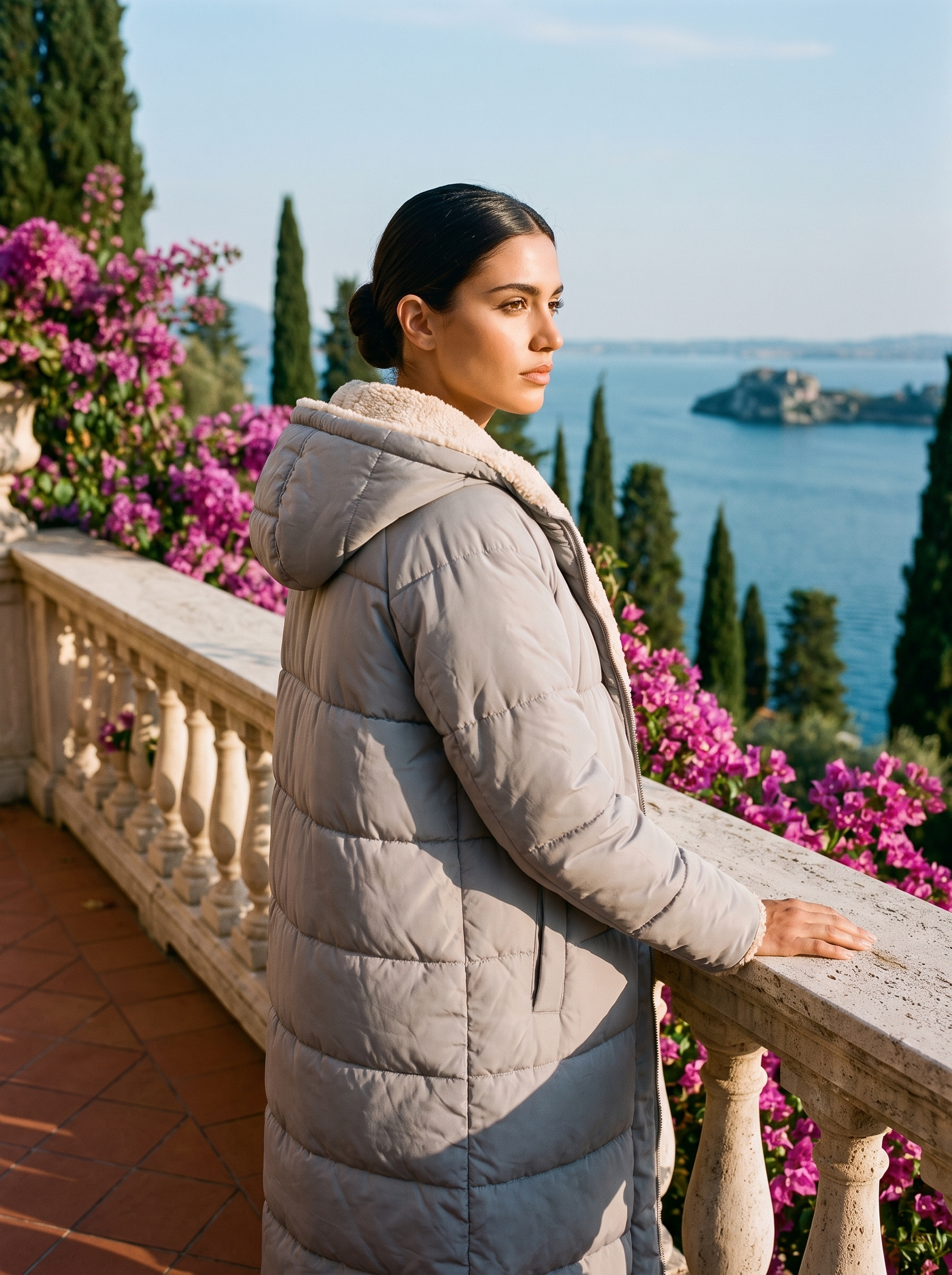 Woman wearing grey puffer coat on a Lake Como terrace — Aveloire