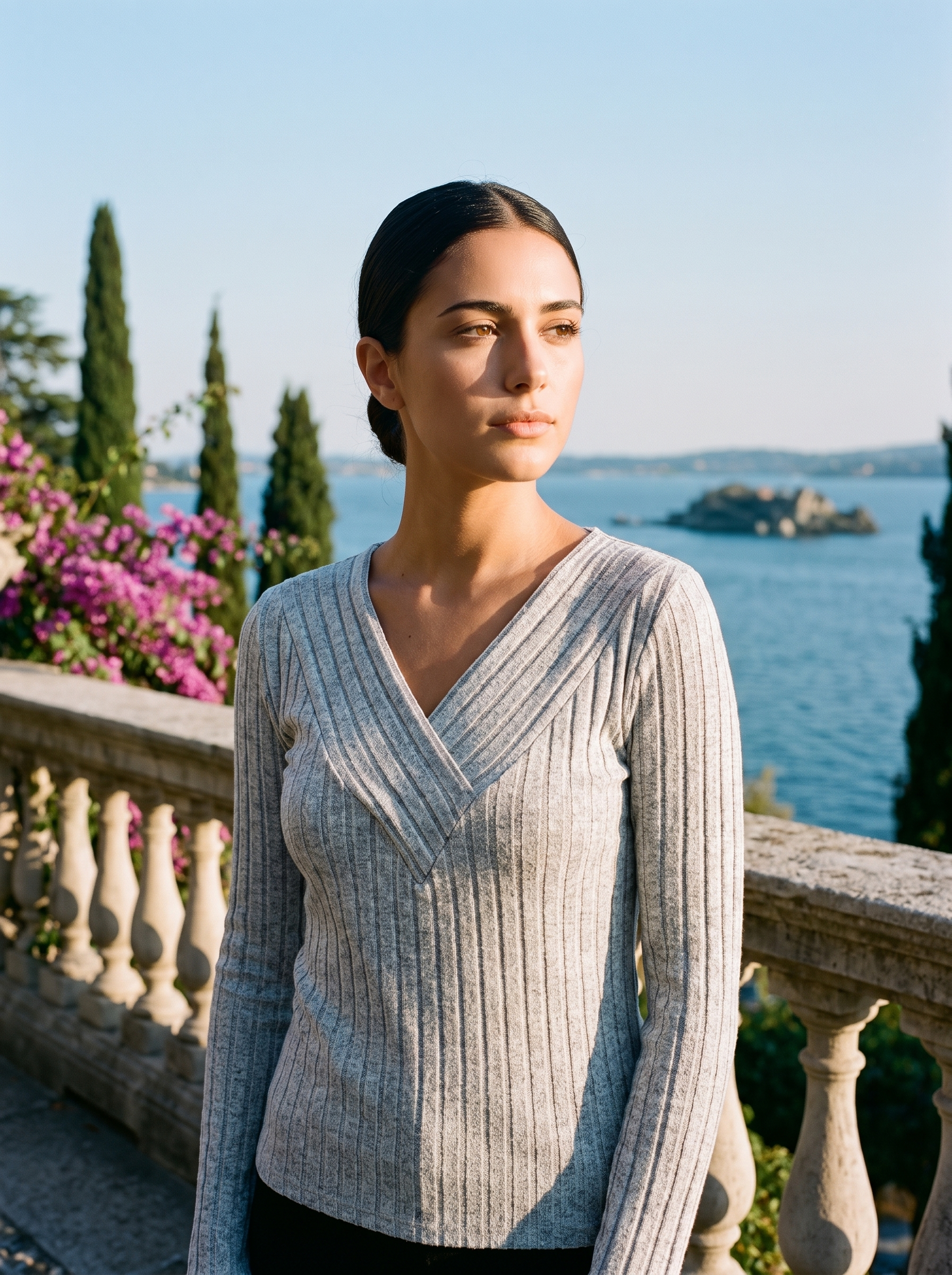 Woman wearing a grey ribbed V-neck top on a terrace overlooking Lake Como — Aveloire
