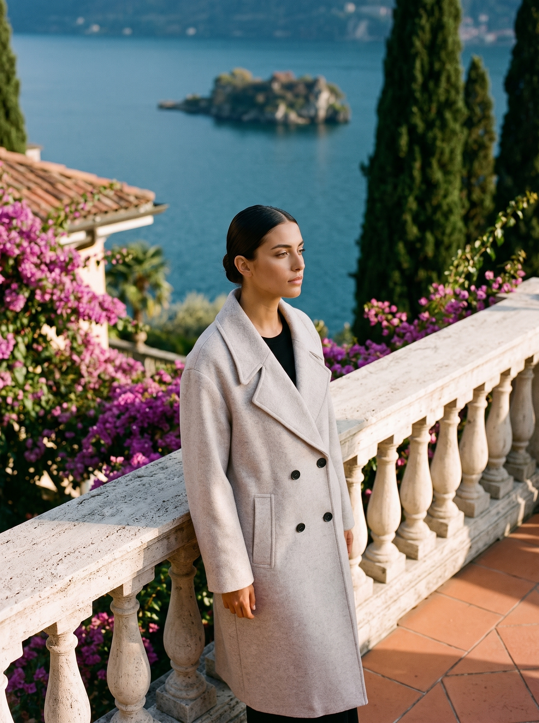 Woman wearing a light-grey double-breasted wool overcoat on a Lake Como terrace — Aveloire