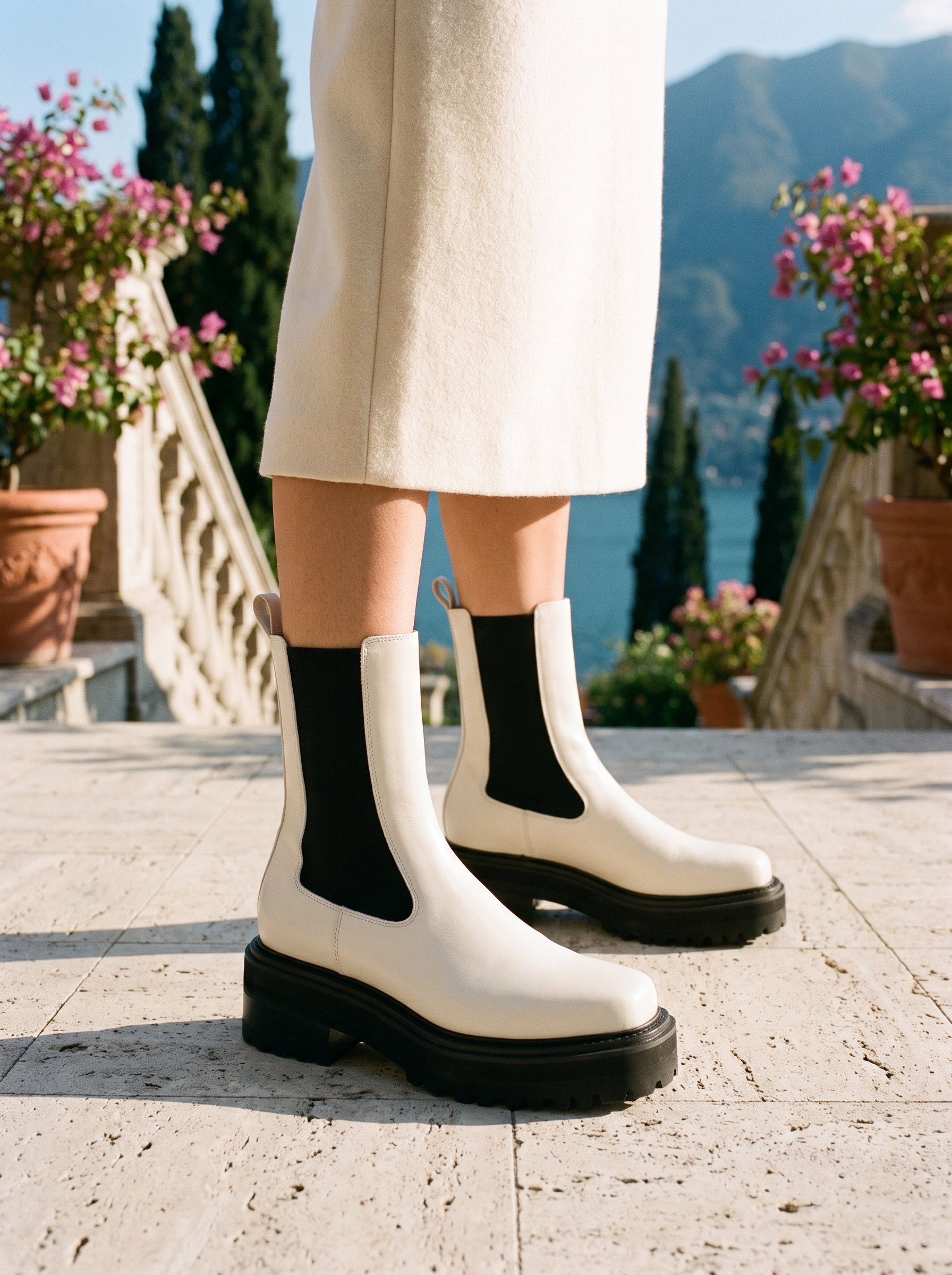 Woman wearing white two-tone Chelsea platform boots on a terrace overlooking Lake Como, old money style — Aveloire